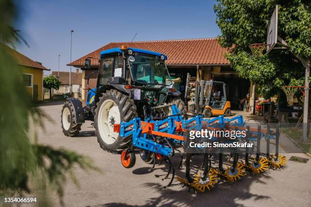 tractor en el patio de la granja - harrow fotografías e imágenes de stock
