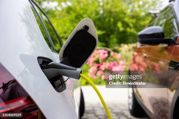 recharger une voiture électrique à la maison - chargeur de batterie photos et images de collection