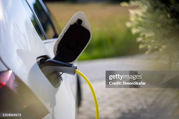 cargar un coche eléctrico en casa - cargar fotografías e imágenes de stock