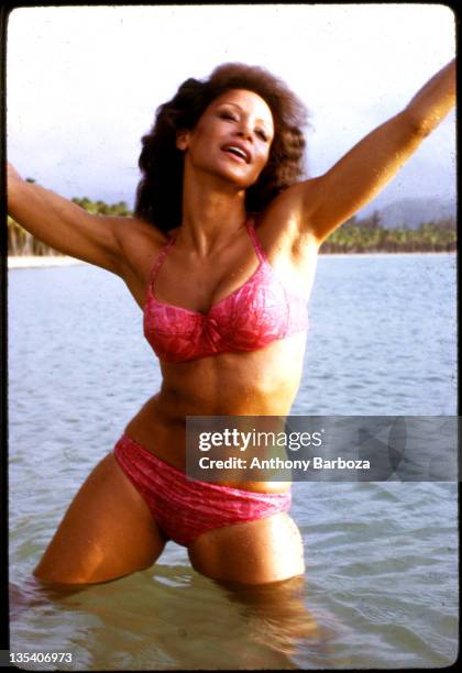 Portrait of American singer and actress Freda Payne, dressed in a bikini, as she stands in the water, her arms in the air, Puerto Rico, 1980s.
