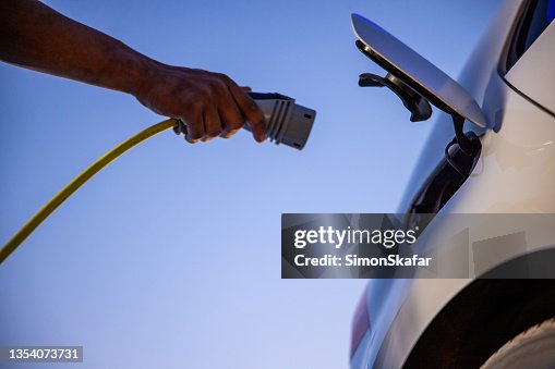 Plugging in electric car for charging Plugging in electric car for charging
