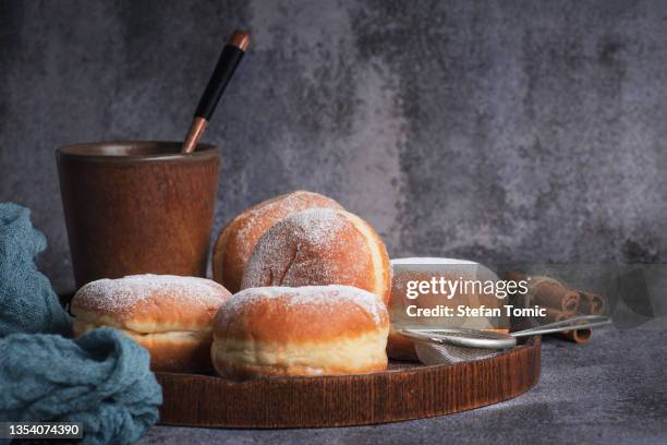 donuts recheados com geleia polvilhada com açúcar em pó e xícara de leite - doughnut - fotografias e filmes do acervo