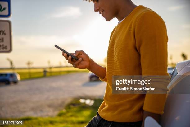 silhouette of man using mobile phone outdoors - phone leaning stock pictures, royalty-free photos & images