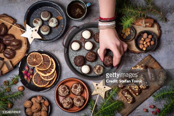 woman serving luxurious, homemade chocolate praline candies - temptation stock pictures, royalty-free photos & images