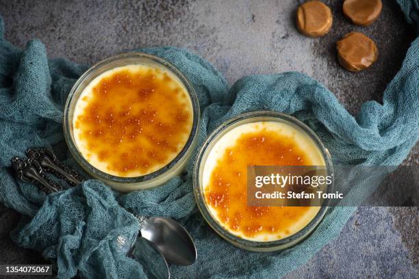 französische vanillecreme. zwei glasschalen mit traditionellem cream dessert - creme brulee stock-fotos und bilder
