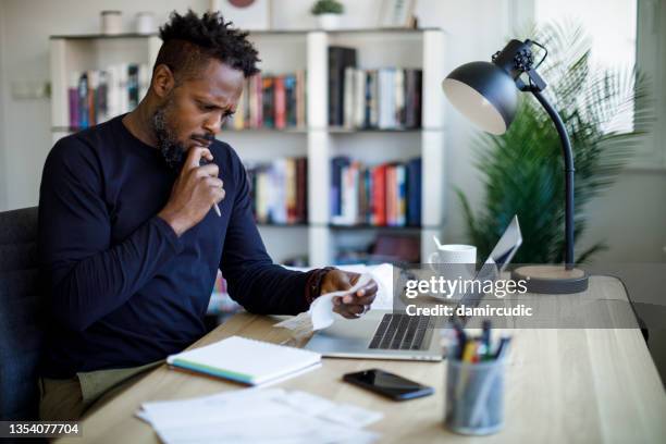 homme calculant le budget et les finances - bulletin-de-paie photos et images de collection