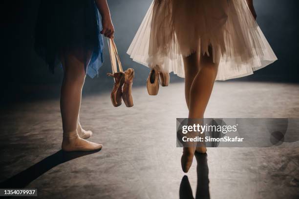 two ballerinas carrying her ballet shoes while walking on the stage - tutu stock pictures, royalty-free photos & images