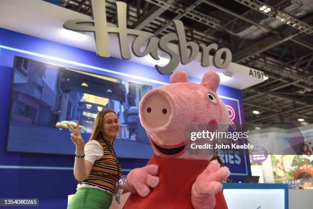 Woman poses with a Pegga Pig character at the Hasbro stand during Brand Licensing Europe at ExCel on November 18, 2021 in London, England. Brand...