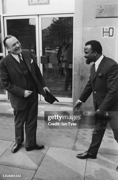 Black passer-by stops to shake hands with British Conservative MP Enoch Powell outside ATV House, the studios of Thames Television on Kingsway,...