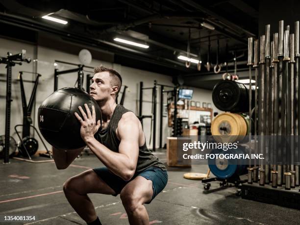 man exercising with beanbag in the gym - training bean bag stock pictures, royalty-free photos & images