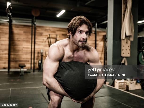 man exercising with beanbag in the gym - training bean bag stock pictures, royalty-free photos & images