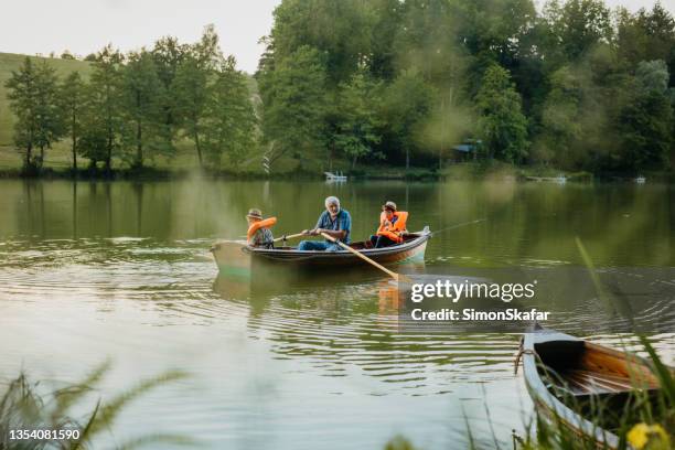 grandfather sitting with grandsons in rowing boat - 9 loch stock pictures, royalty-free photos & images