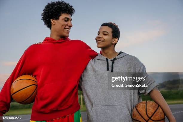 two basketball players embracing on sports court - brothers boys cuddle stock pictures, royalty-free photos & images
