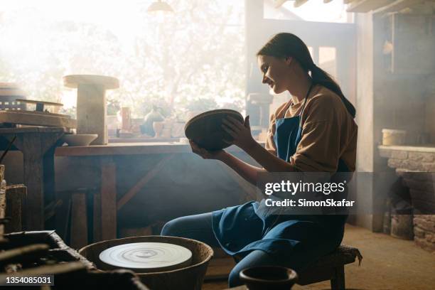 adolescente tenant un bol en argile à l’atelier - poterie photos et images de collection