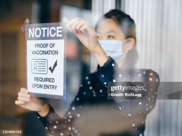 business owner wtih vaccine mandate sign - mandate stock pictures, royalty-free photos & images