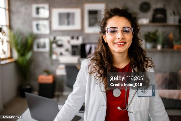 smiling happy young female doctor or nurse - epidemiology stock pictures, royalty-free photos & images