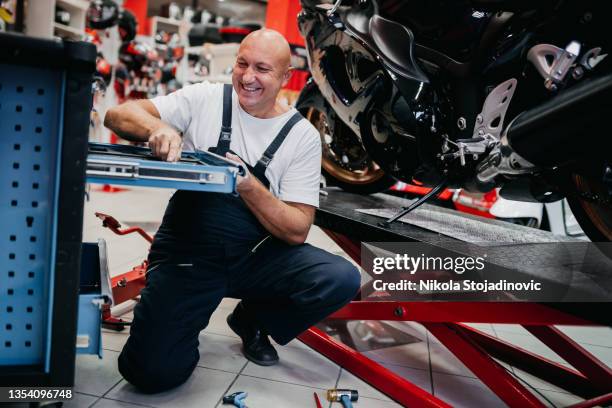 mecânico reparando motocicleta - instruções - fotografias e filmes do acervo