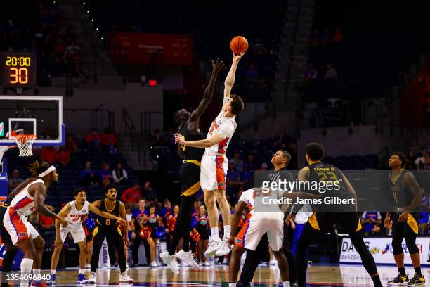 Colin Castleton of the Florida Gators jumps for the ball against Moses Bol of the Milwaukee Panthers during the first half of a game at Stephen C....