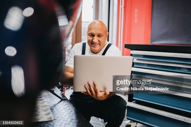 the mechanic uses a laptop - broken laptop stockfoto's en -beelden