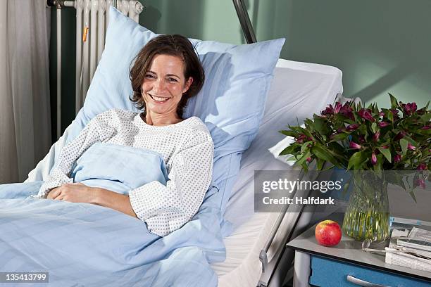 portrait of woman lying in a hospital bed - flower bed stockfoto's en -beelden