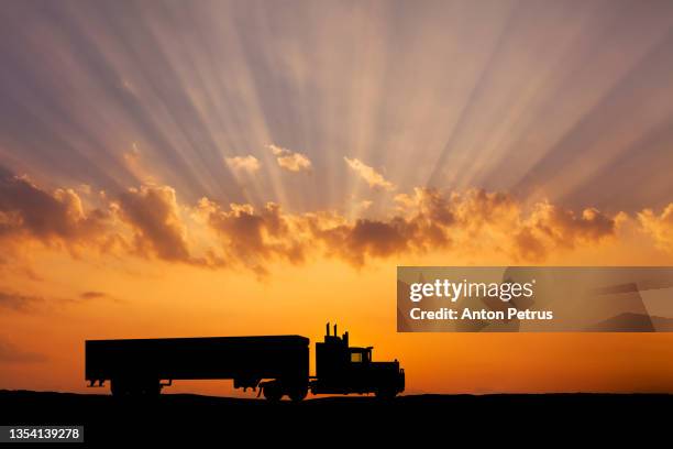 silhouette of a semi truck on the road on the background of the sunset sky - highway dusk stock pictures, royalty-free photos & images