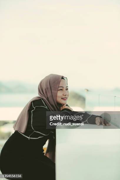 asiatische hijab-frau genießt reisen in labuan bajo - muslim woman beach stock-fotos und bilder