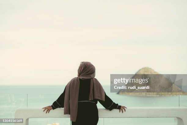 rückansicht asiatische hijab-frau genießt reisen in labuan bajo - hijab woman from behind stock-fotos und bilder