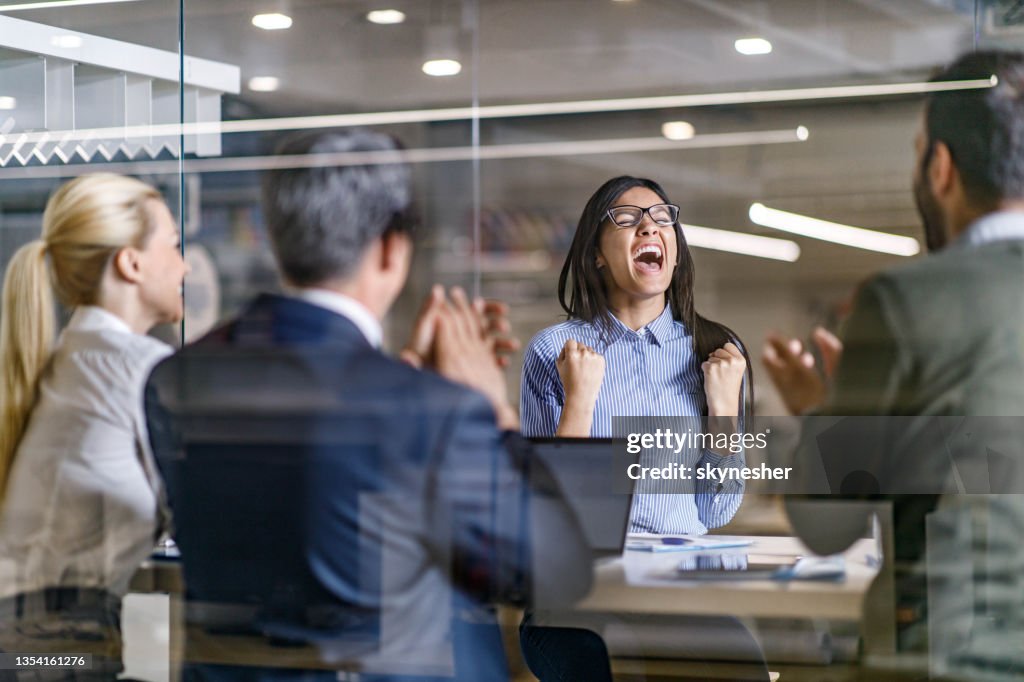 Cheerful female candidate celebrating getting a job on an interview in the office.
