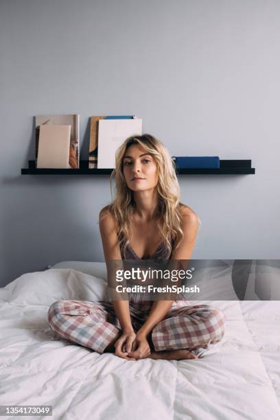 ベッドの上の蓮の位置に座っている美しい女性 - comfort zone ストックフォトと画像