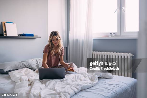 a blonde female enjoying working from home - telecommuting eating stock pictures, royalty-free photos & images