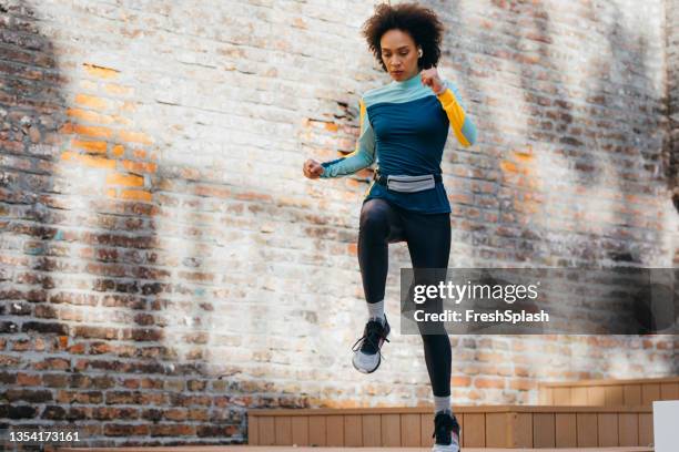 una chica afroamericana decidida haciendo su entrenamiento matutino antes del trabajo - bolsa canguro fotografías e imágenes de stock