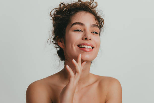 smiling young woman with curly hear and clear skin - mulher bonita imagens e fotografias de stock