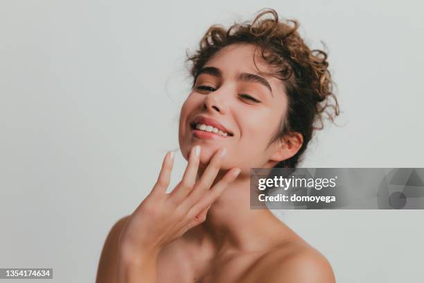 smiling young woman with curly hear and clear skin - no make up stock pictures, royalty-free photos & images