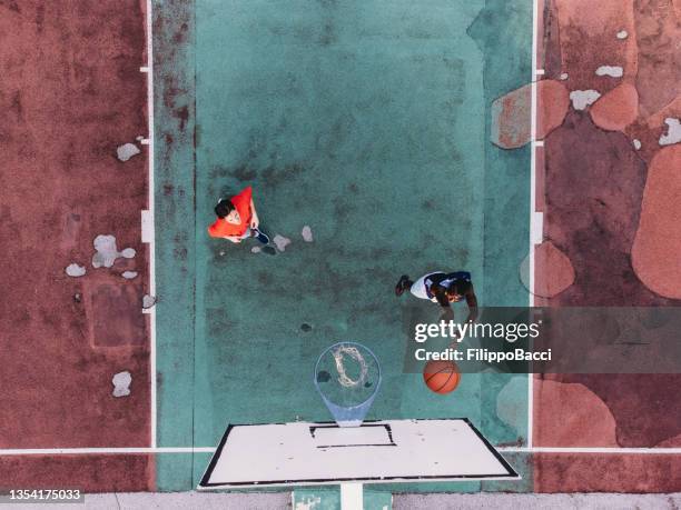 two friends are playing basketball together - aerial point of view - bad condition stock pictures, royalty-free photos & images
