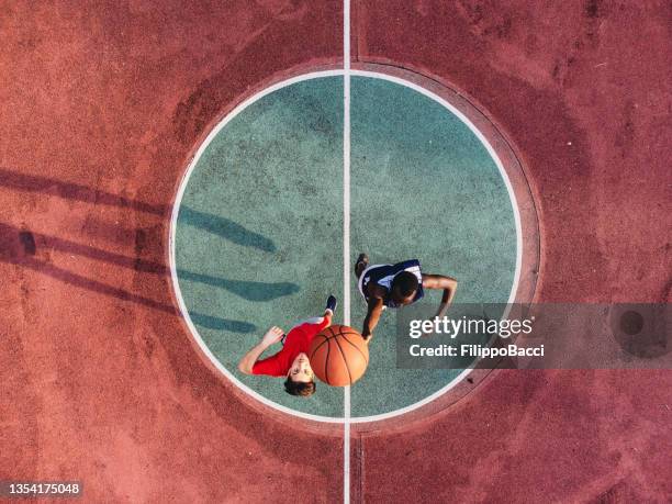 two friends are jumping to take a basketball ball on the center field - aerial people circle stock pictures, royalty-free photos & images