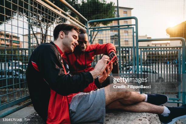 two friends are resting after a basketball match - sports equipment stock pictures, royalty-free photos & images