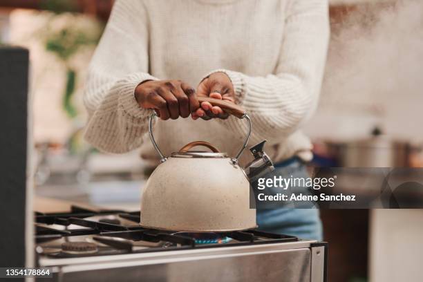 aufnahme einer nicht erkennbaren person, die zu hause wasser auf dem herd kocht - gas cooking stock-fotos und bilder