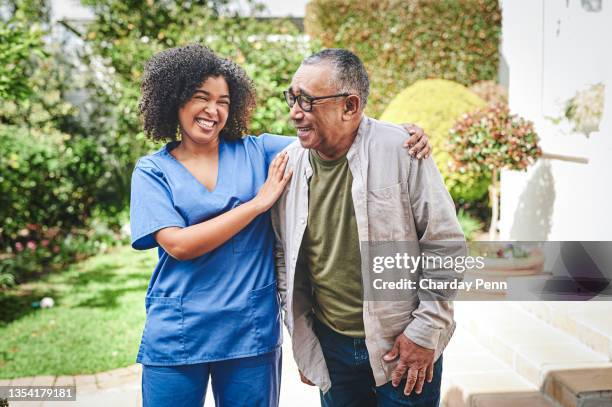 shot of an attractive young nurse bonding with her senior patient outside - aged care stockfoto's en -beelden