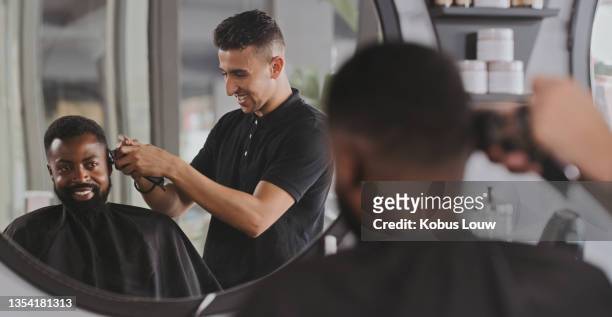 aufnahme eines gutaussehenden jungen mannes, der sich beim friseur die haare schneiden lässt - barbier stock-fotos und bilder