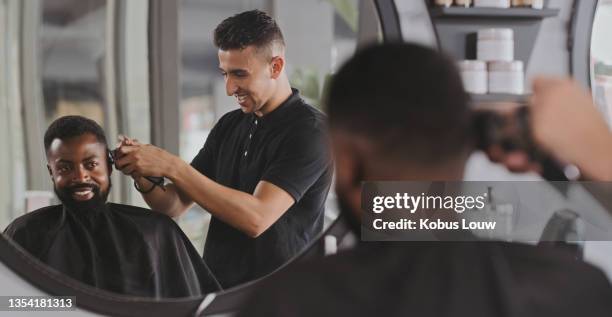 shot of a handsome young man getting his hair cut at the barber - barbers stock pictures, royalty-free photos & images