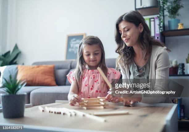 mother and her little girl playing jenga at home - jenga stock pictures, royalty-free photos & images