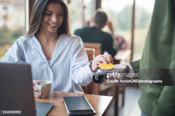 businesswoman making credit card payment while working in cafe - contactless payment 個照片及圖片檔