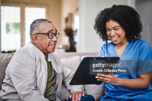 shot of a young nurse sitting on the sofa with her senior patient and using a clipboard during a discussion - clipboard and glasses stock pictures, royalty-free photos & images