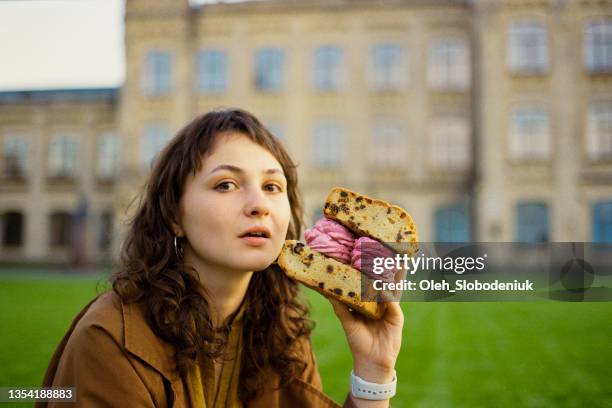 woman eating huge sandwich made of biscuit and marshmallow - old fashioned candy stock pictures, royalty-free photos & images