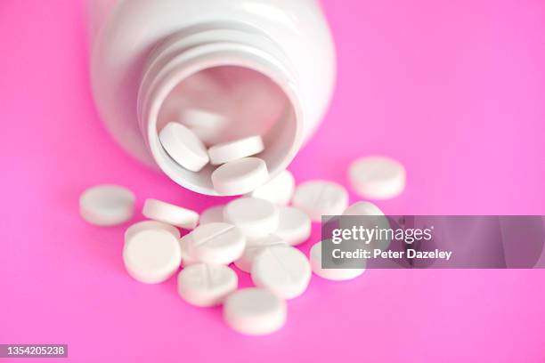 pills on pink background - ibuprofen stock pictures, royalty-free photos & images