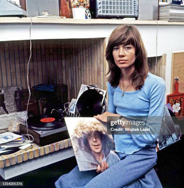 French singer, songwriter and actress Francoise Hardy holds a record "Paul Simon" by Paul Simon as she poses at her apartment in Paris, September...