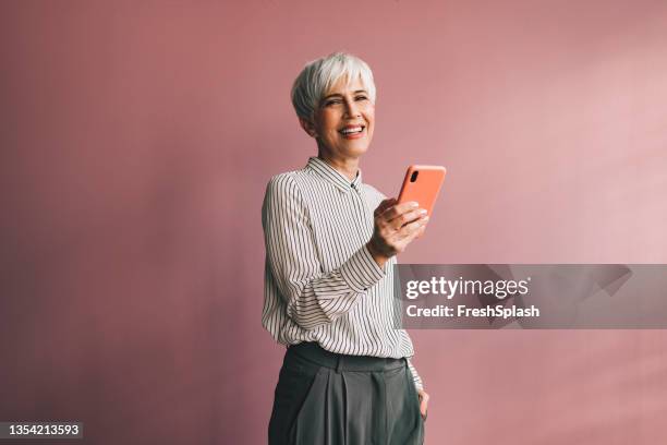 retrato de una mujer de negocios de alto nivel usando un teléfono móvil - celular fotografías e imágenes de stock