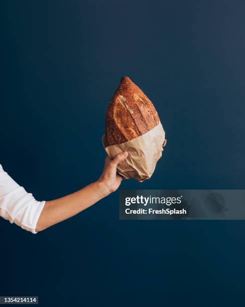 nahaufnahme foto von frau hand halten frisch gebackenes brot - bread close up stock-fotos und bilder