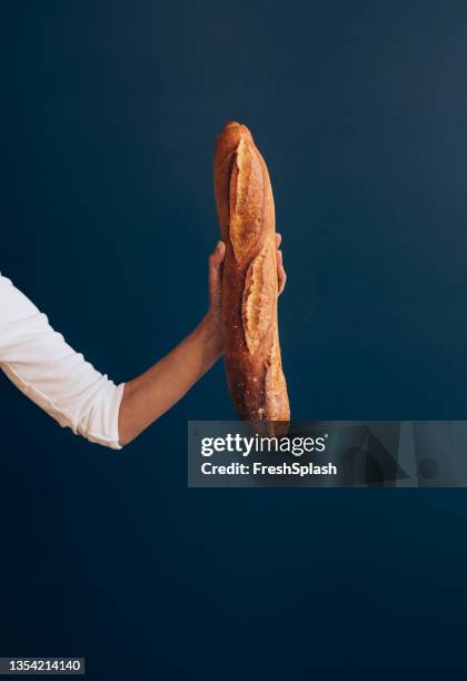 close up photo of woman hand holding freshly made baguette - french bread stock pictures, royalty-free photos & images