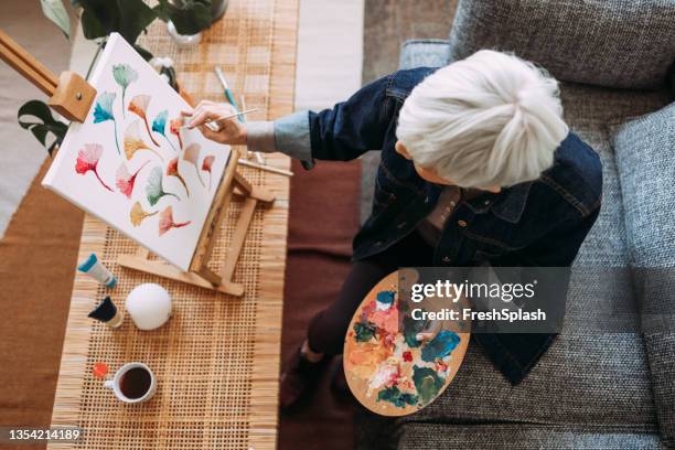 an anonymous female artist painting at home - paintings stock pictures, royalty-free photos & images